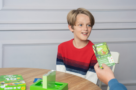 Boy guessing an animal card from the Guess in 10 Animal Planet card game from Skillmatics