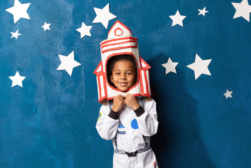 Child wearing an astronaut costume with a rocket headpiece for space STEM activities