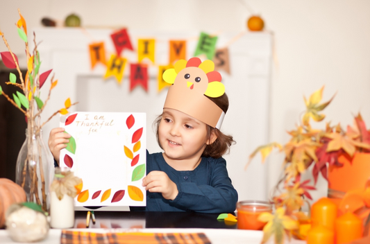 Kid holding a thanksgiving printable with the words "I am thankful for...."