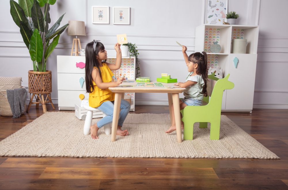 two little girls sitting on a table and playing Memory Match by Skillmatics