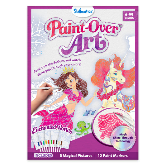 Front view of Skillmatics Paint-Over Art kit box showing enchanted fantasy theme with mermaid and unicorn artwork, child hand using marker, 'Mess Free' label, Magic Shine-Through Technology badge, includes 5 magical pictures and 10 paint markers, ages 6–99 listed on packaging.