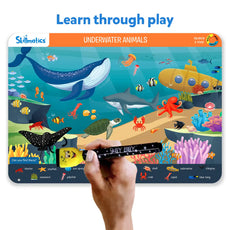 Skillmatics underwater animals learning board with a hand holding a pen.