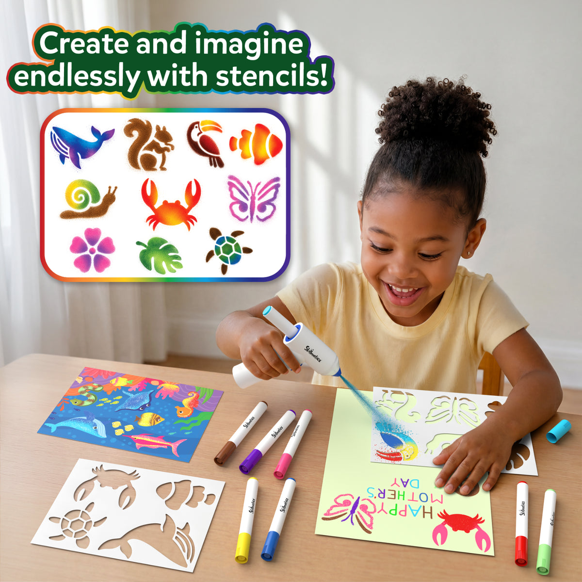A smiling child uses the Skillmatics Spraybrush Art tool to spray blue colour through animal stencils onto paper. Colourful markers, stencil sheets, and an underwater picture board sit on the table. A panel displays whale, squirrel, toucan, fish, crab, butterfly, flower, and leaf designs.