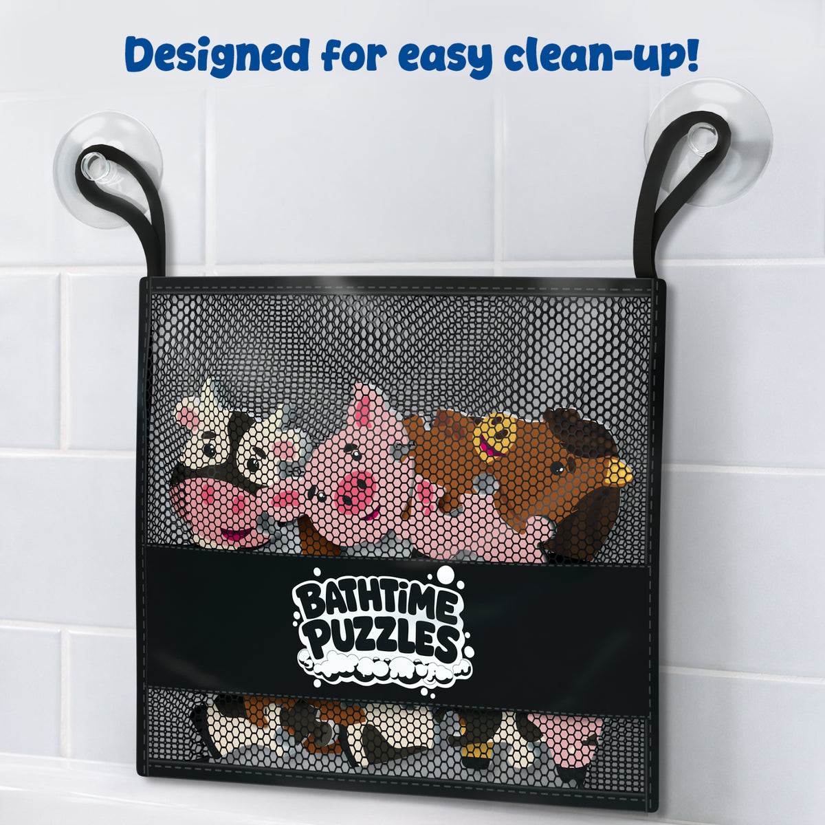 A black mesh storage bag labeled "Bathtime Puzzles" hangs from a bathroom wall hook against white tiles. The bag contains colorful foam farm animal puzzle pieces and demonstrates convenient storage, quick drying, and easy clean-up after bath play sessions for young children.