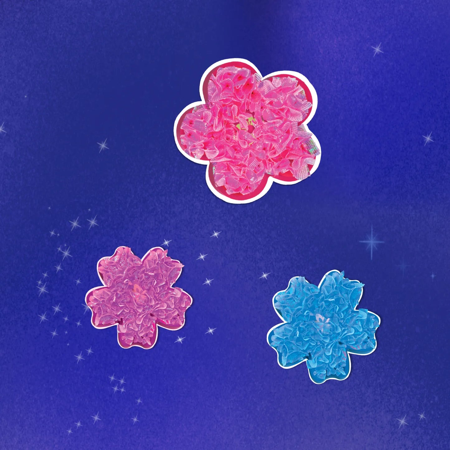 Three completed poke-in flowers made with layered fabric squares in bright pink, purple, and blue shades, shown on a starry purple background.