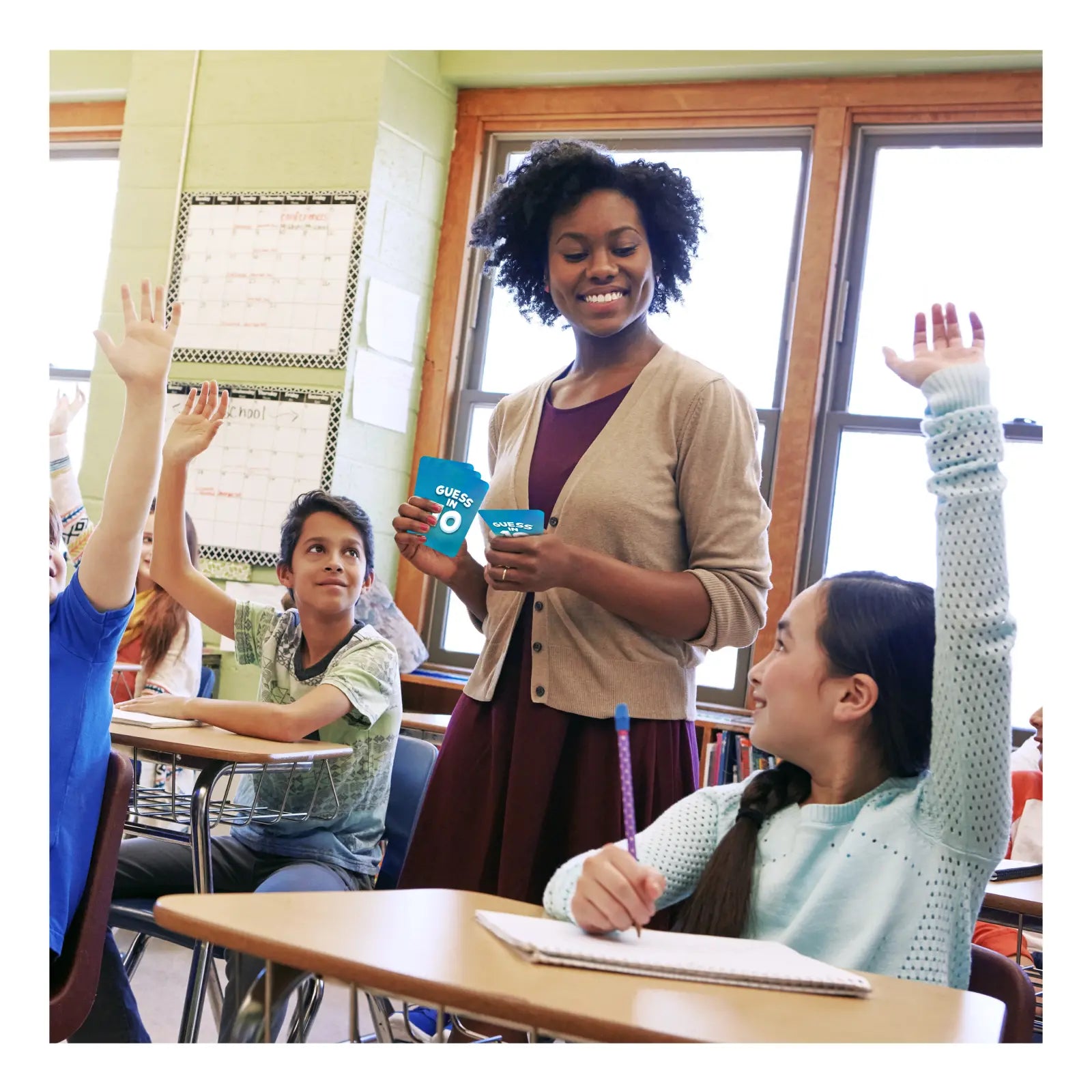 Teacher holding blue cards for Science Snippets Animals and Guess in 10 US History